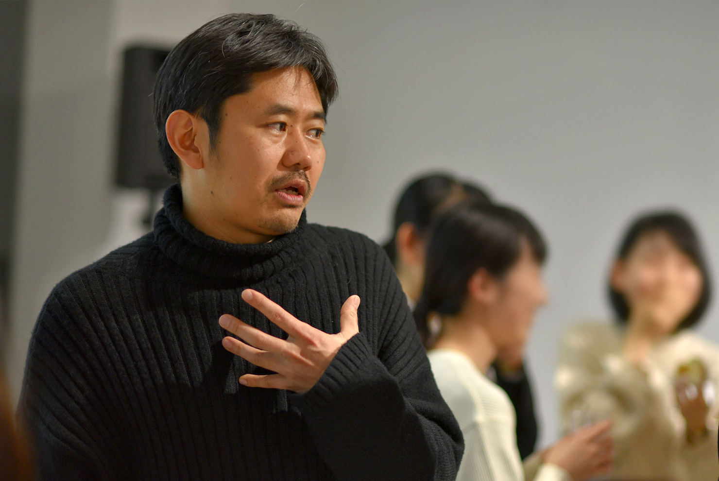 写真：交流会で参加書と話す長谷川敦士