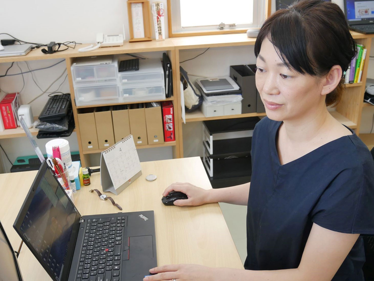 写真:識名が沖縄オフィスでの業務をしている様子