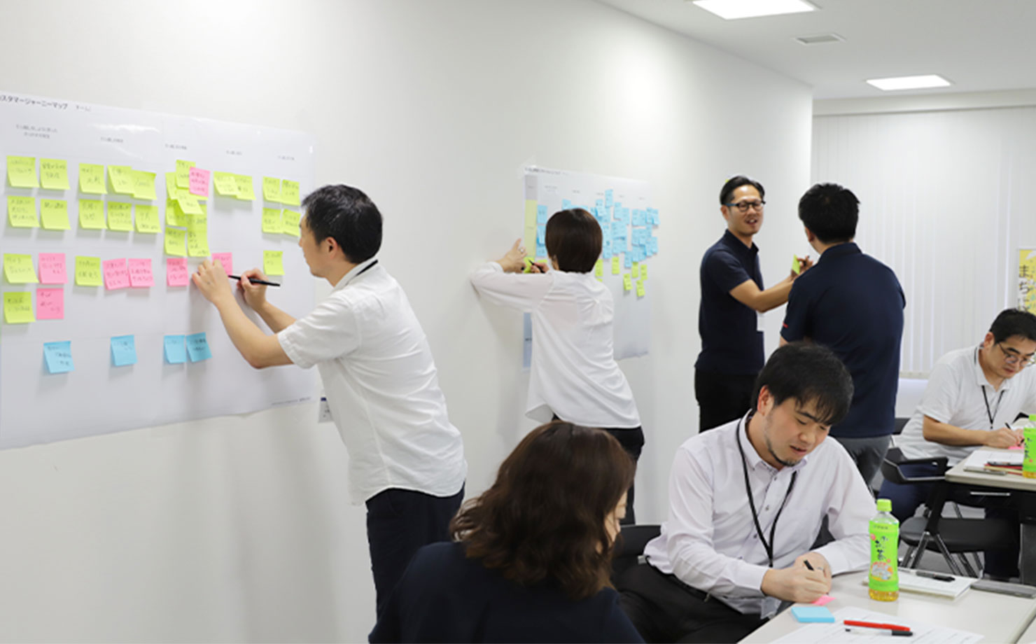 写真：2日目の様子。ボードに付箋を貼ったり、話し合ったり、積極的に参加している参加者たち。