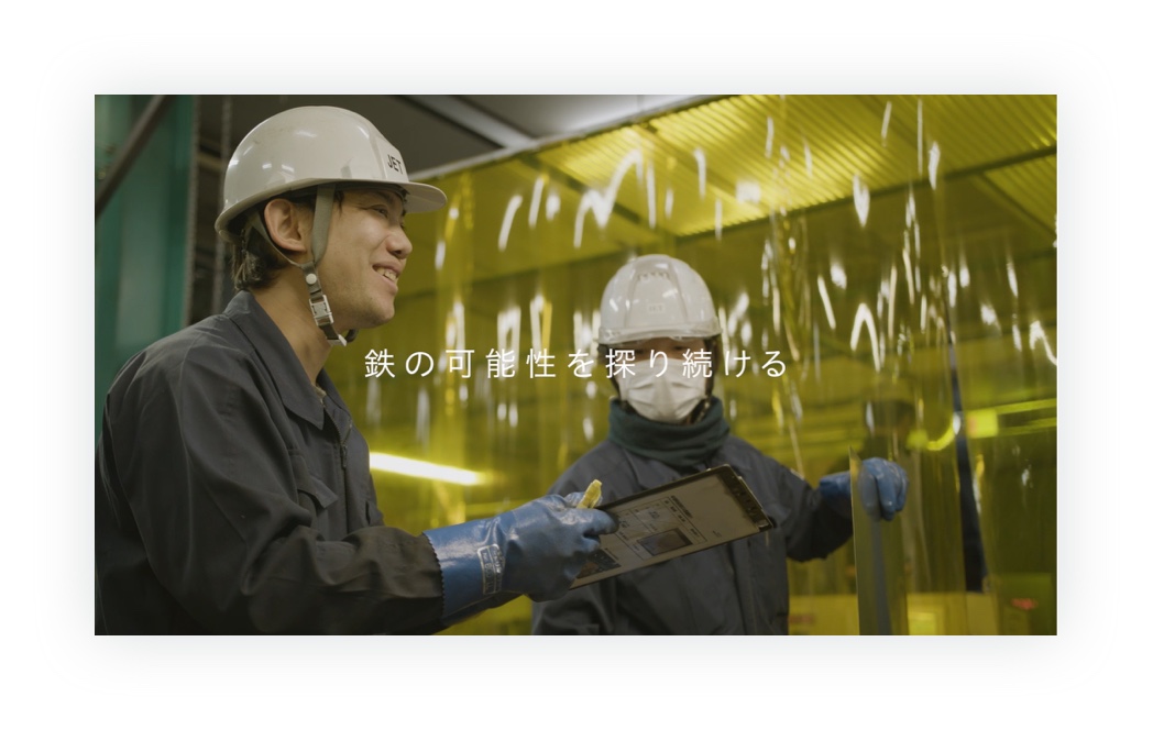 制作した動画のキャプチャ（8枚中6枚目）：ヘルメットをかぶり作業着を着た富安の作業員2名が仕事をしている様子。その画面の上に「鉄の可能性を探り続ける」の文字が書かれている。