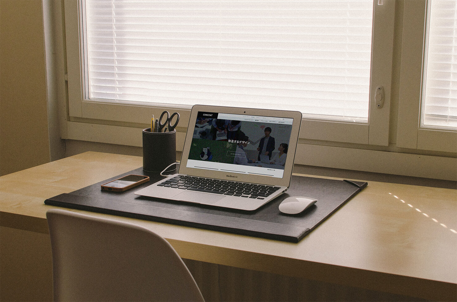 写真：窓辺の机にパソコンが置いてあり、コンセントのウエブサイトが開かれている。