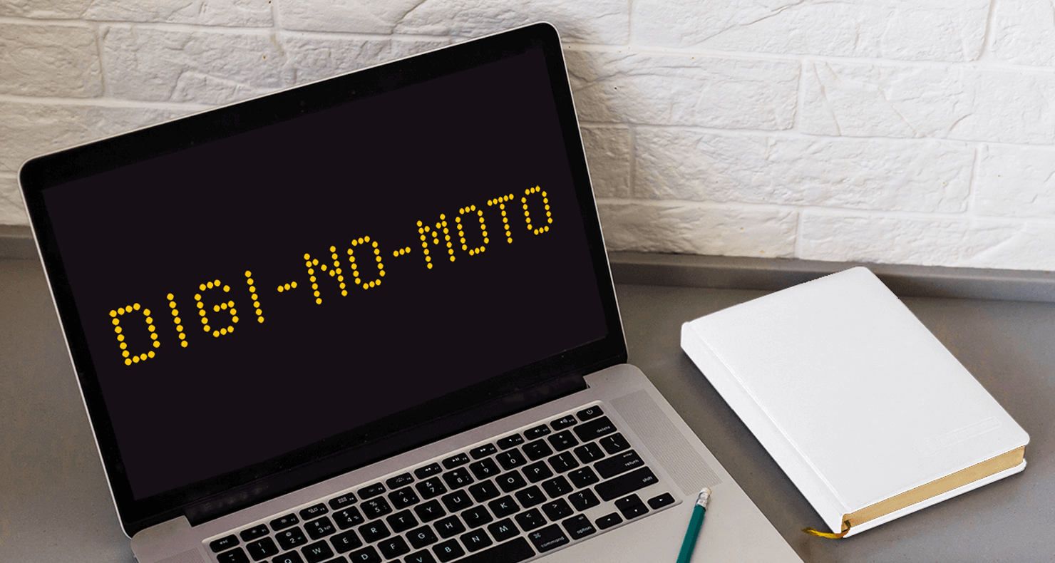 机の上に「DIGI-NO-MOTO」のロゴが表示されたノートPCと手帳が置かれている。