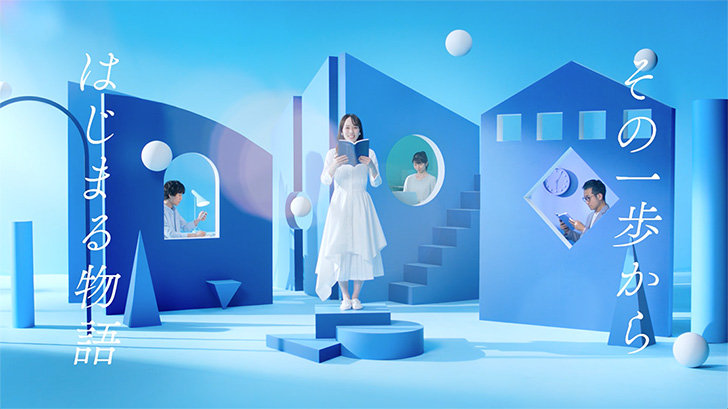 コンセプトムービーのキャプチャ:10枚中8枚目。スタジオセットと男性、女性の全体像が映る。テロップ「その一歩からはじまる物語」