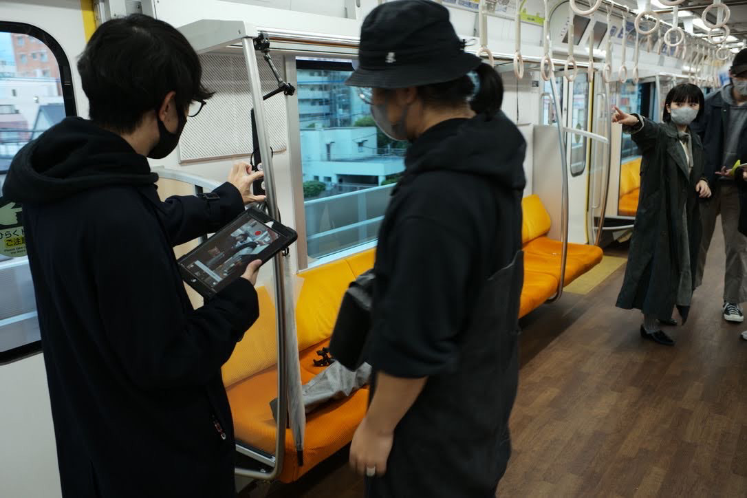 小田急電鉄さまの回送電車をお借りしてのVR撮影中の写真。カメラの位置をチェックしている様子が写っている。