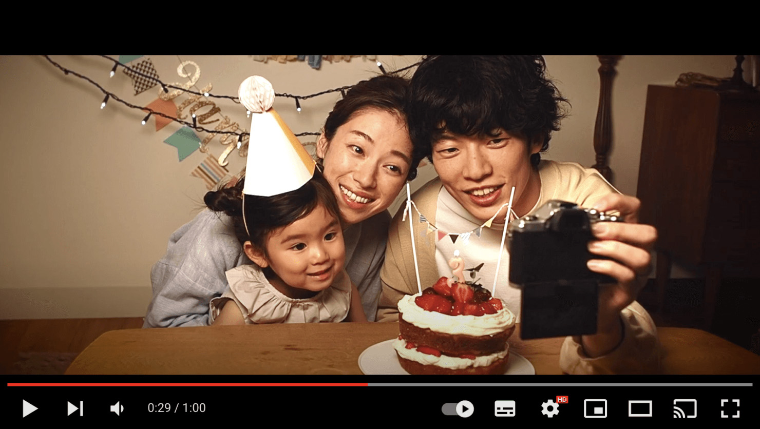 動画キャプチャ:プロモーションムービーの一部抜粋。子どもの誕生日パーティーの中、パパがママ、子どもと一緒にカメラを使って自撮りしている様子