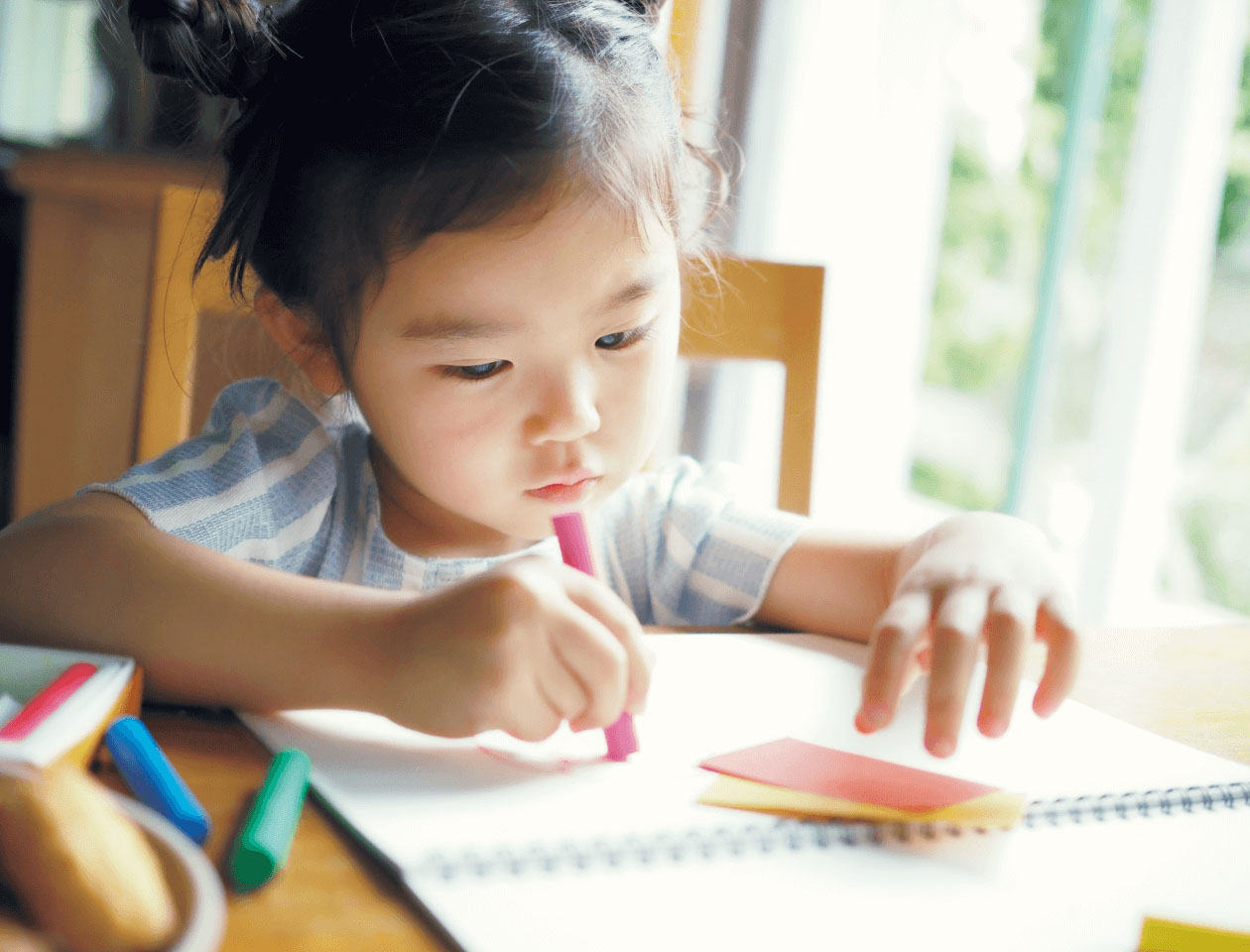 9枚中3枚目：作例写真の一部抜粋。子どもが絵を書いている様子