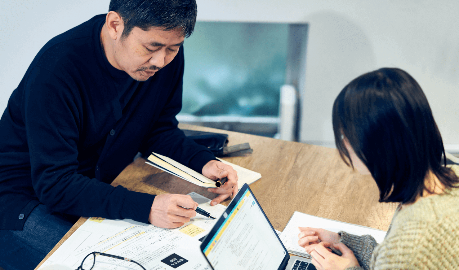 写真:長谷川と坂本が話し合っている様子。