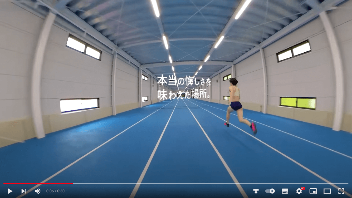 動画キャプチャ:学生が屋内トラックで、空中に浮かぶ「本当の悔しさを味わえた場所。」のコピーに向かって走っている様子