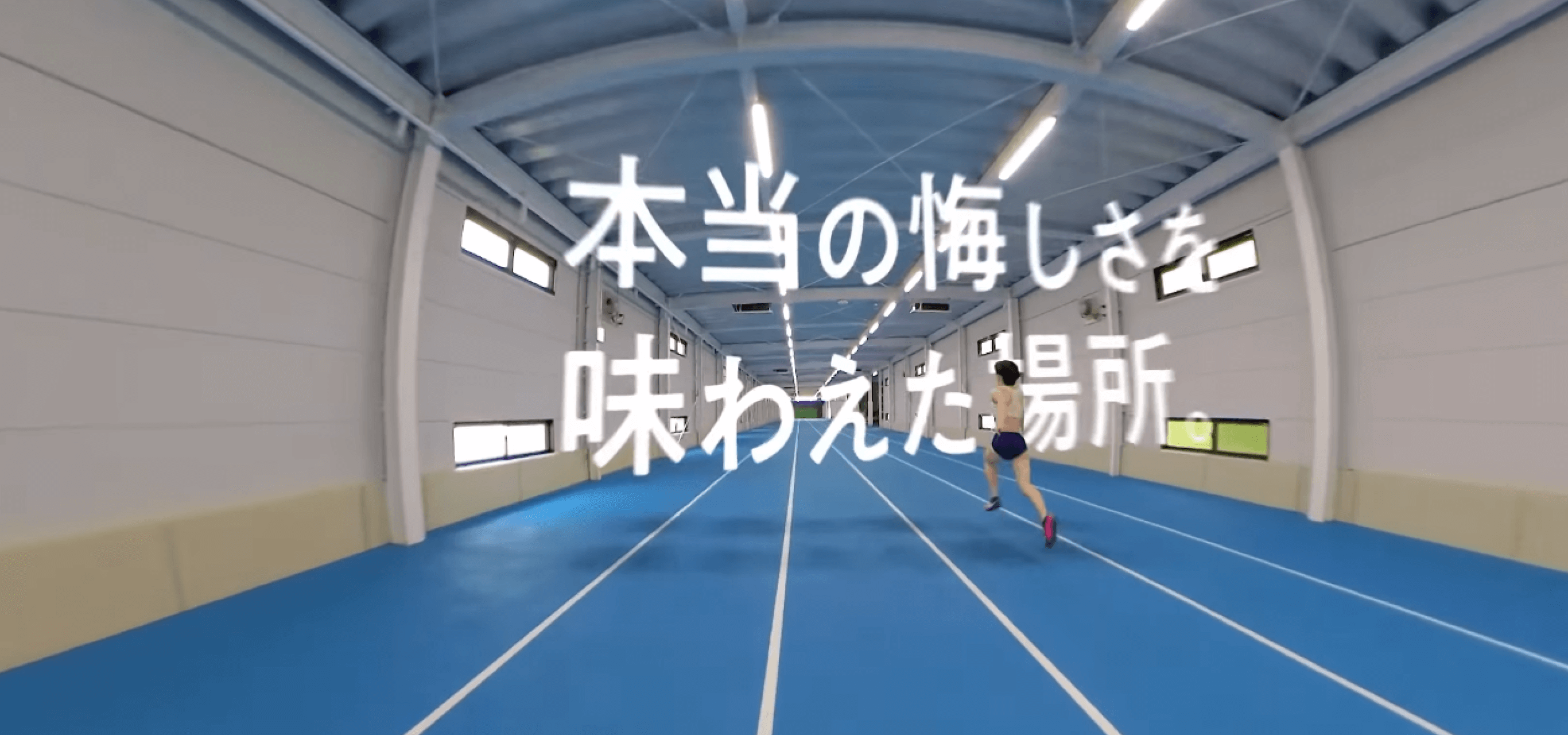 動画キャプチャ:学生が屋内トラックで、空中に浮かぶ「本当の悔しさを味わえた場所。」のコピーに向かって走っている様子