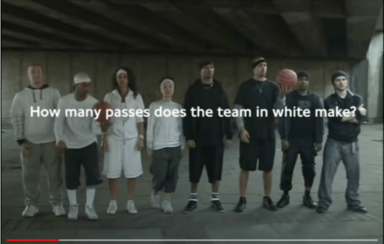 広告動画キャプチャ:一列に並ぶ男女8名と「How many passes does the team in white make?」のメッセージ