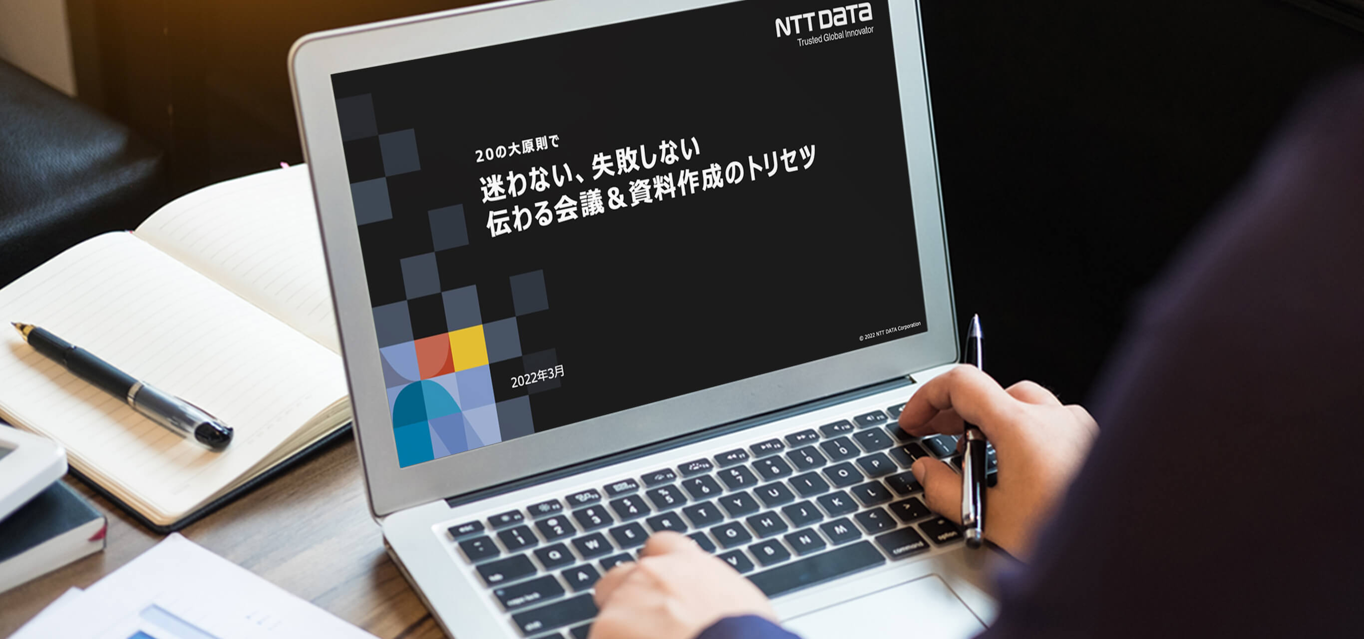 メインビジュアル：今回のプロジェクトで納品した資料がPC画面に投影されている様子。