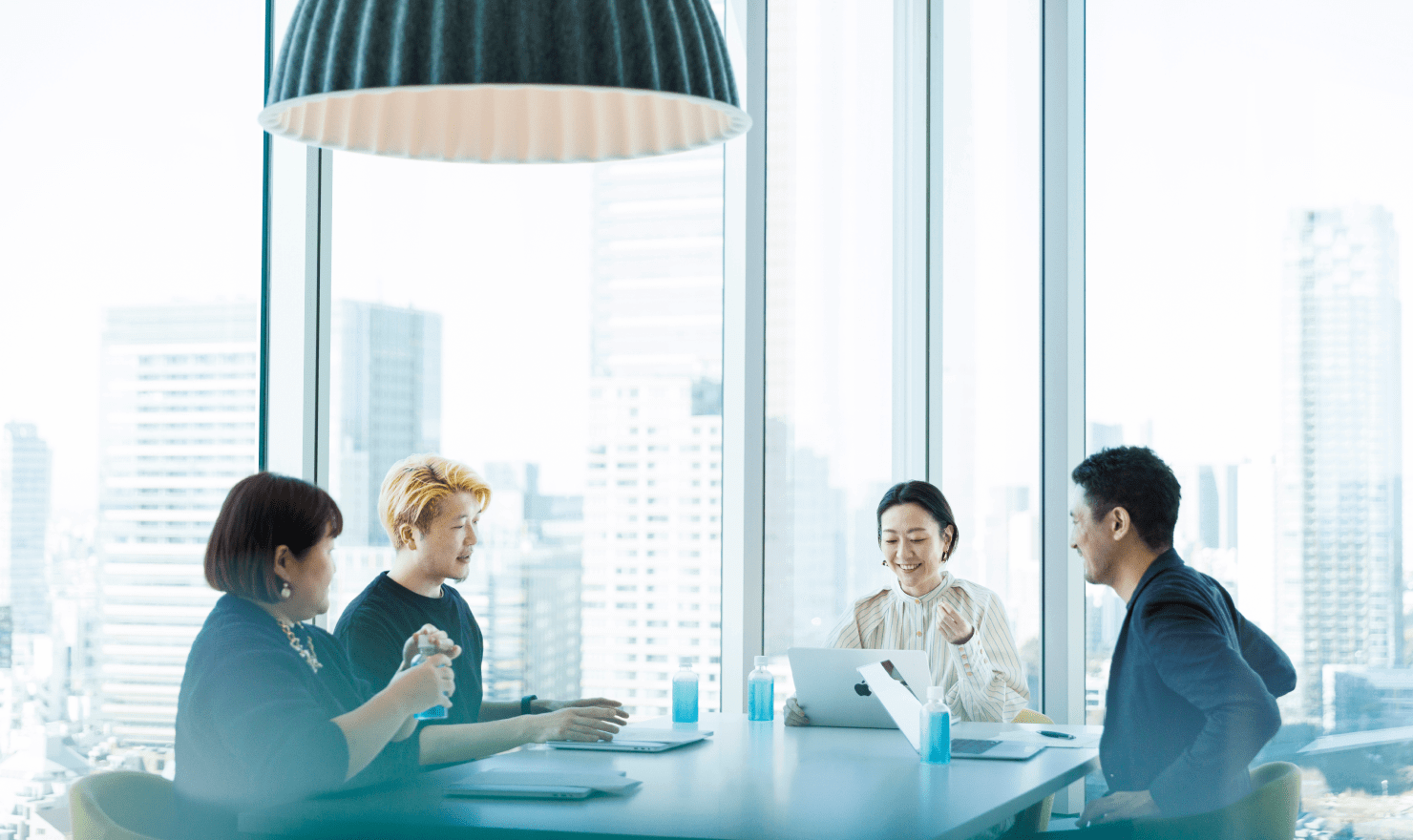写真:座談会参加メンバー4名の写真。机を囲み、笑顔で会話をしている。