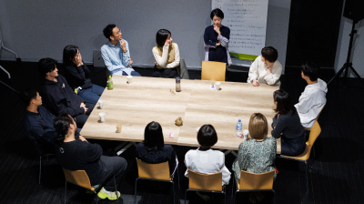 会場の様子。机を囲む形で、参加者が座っている。