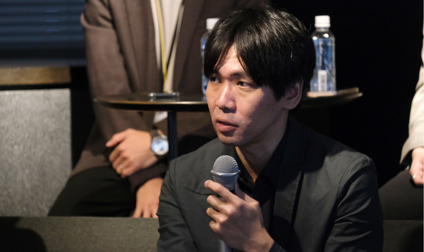 写真。コンセントの岡本が話す様子。