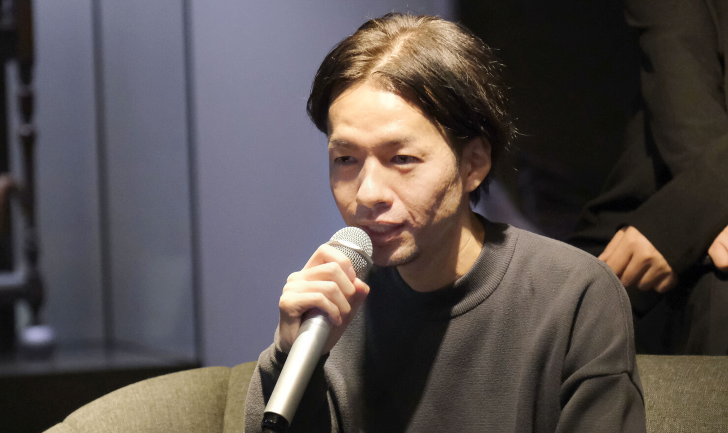 写真。丹青社の鶴岡さんが話す様子。