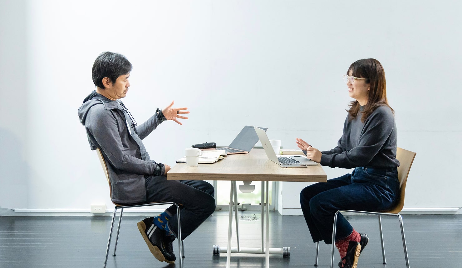 長谷川と鈴木が机を面して対談している様子。