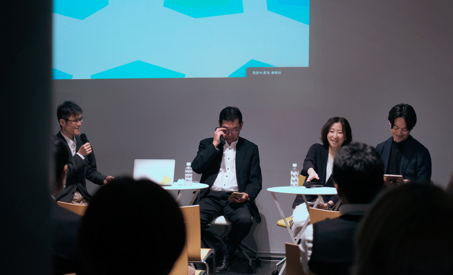 左から、佐藤、山内氏、佐山氏、小林氏の順で座り、身振りも添えながら話している。