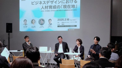 セミナーでのパネルディスカッションの様子。前方の登壇スペースに登壇者4名が椅子に着席し、話している。
