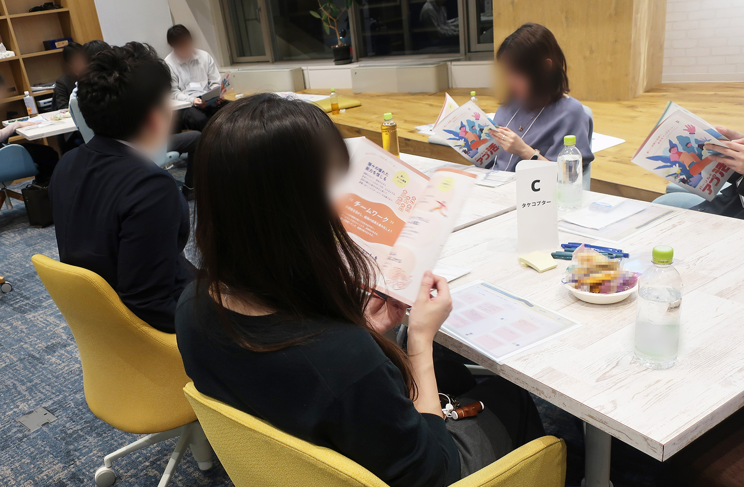 ワークショップで「ヒントBOOK」を見るの参加者たちの様子。