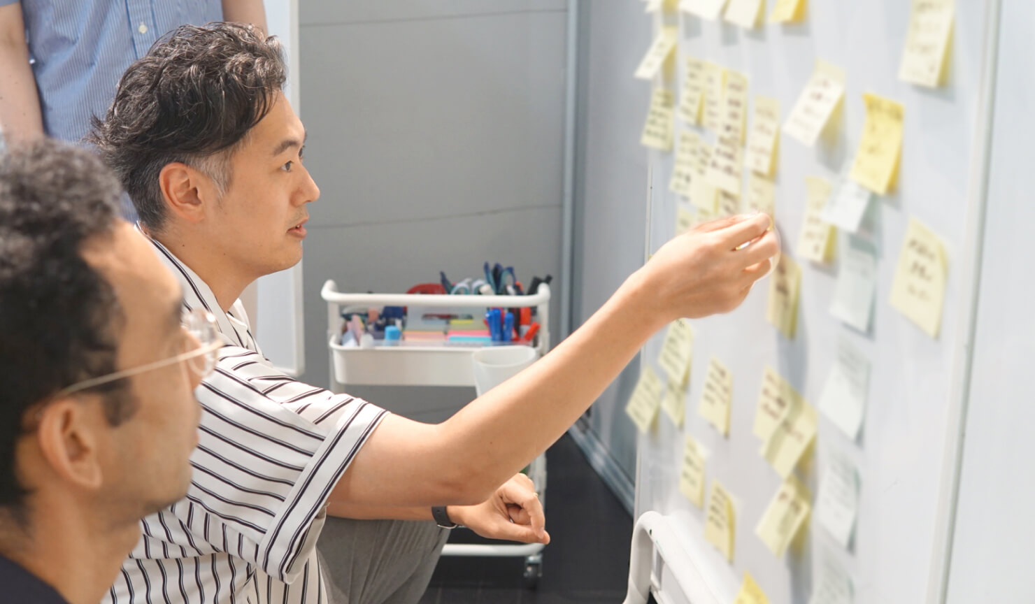 写真。付箋を用いてデジタル庁のメンバーとコンセントのメンバーでブレストを行う様子。