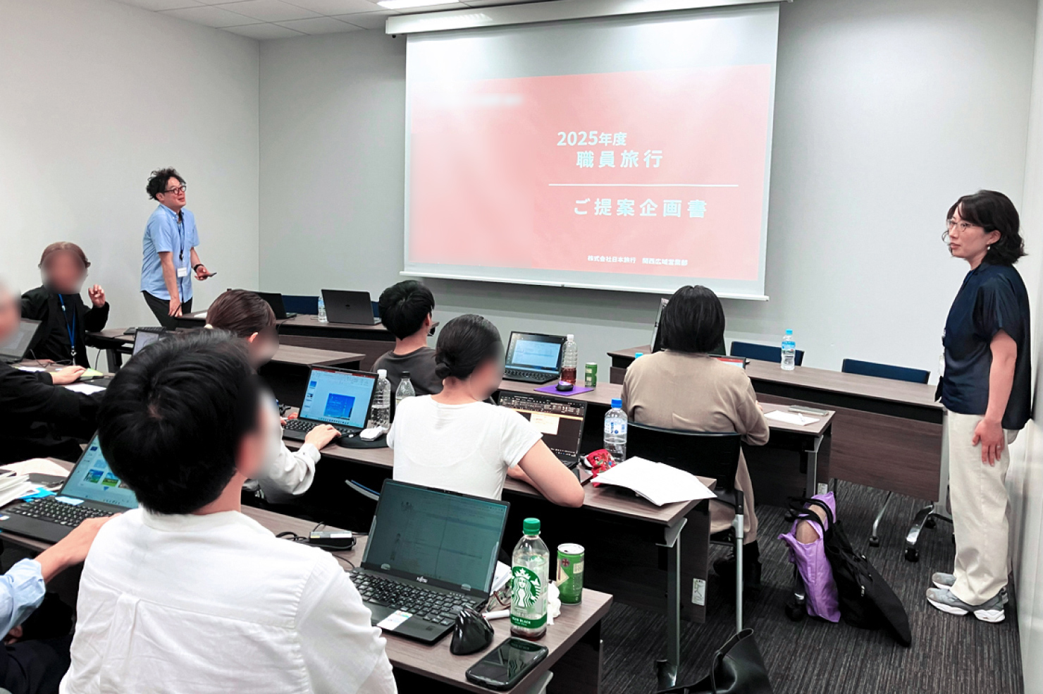 ワークに取り組む受講者と、その様子を見守る講師の写真。