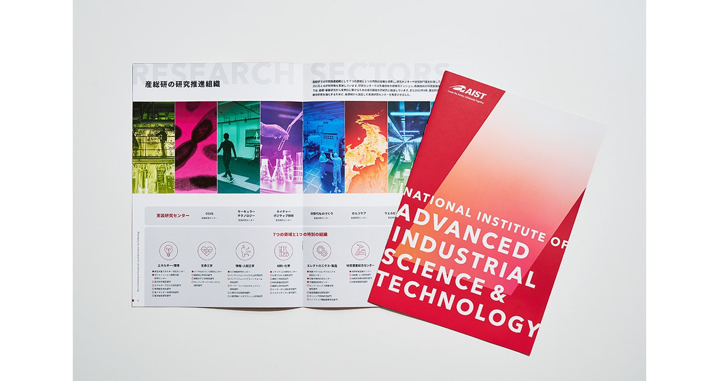 パンフレットの実物写真。ブランドカラーを基調にした赤いグラデーションの表紙と、研究センターを紹介する中面ページを並べて撮影されている。