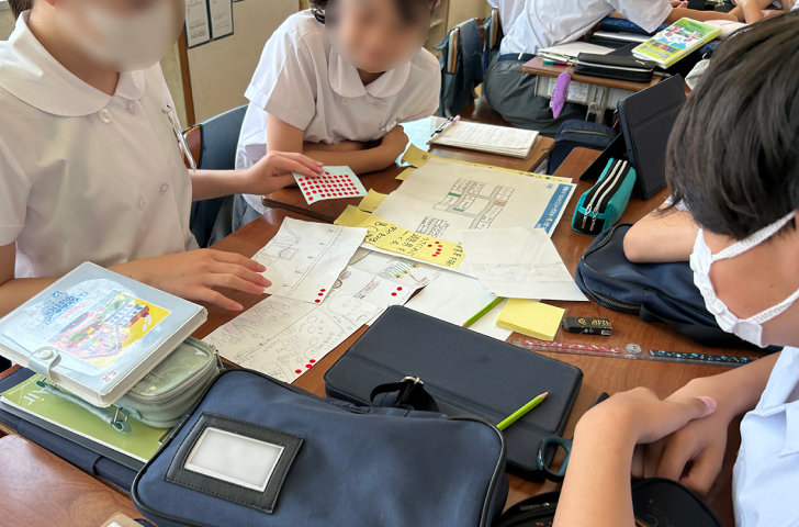 机を並べてアイデアを出し合う児童たち。