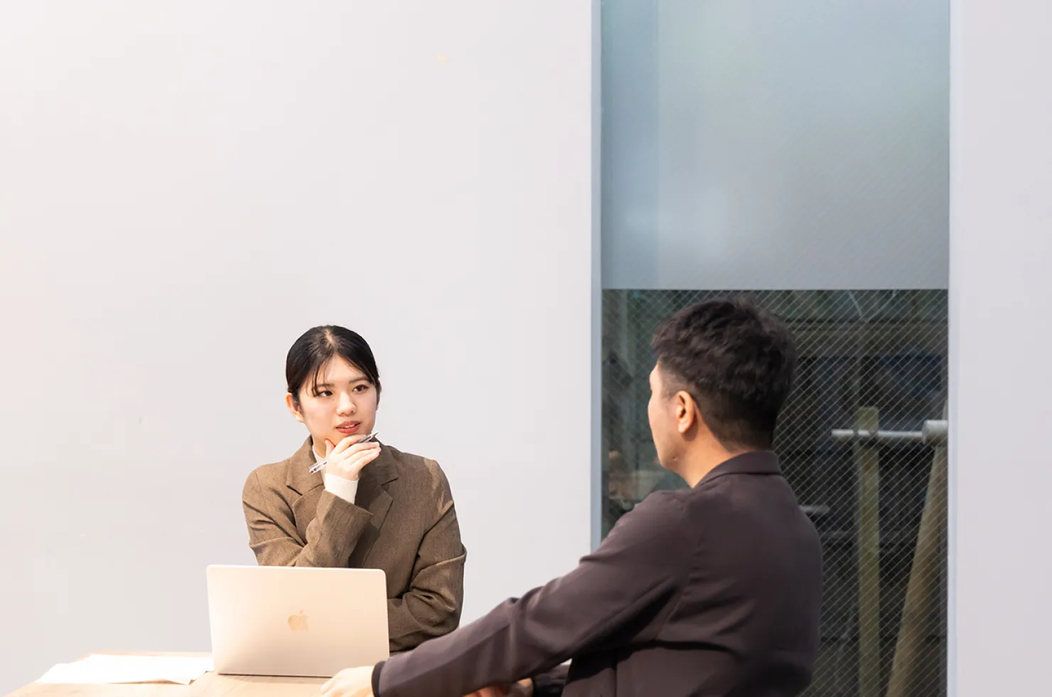 対談の様子。デスクを囲んで話す鈴木と大﨑。