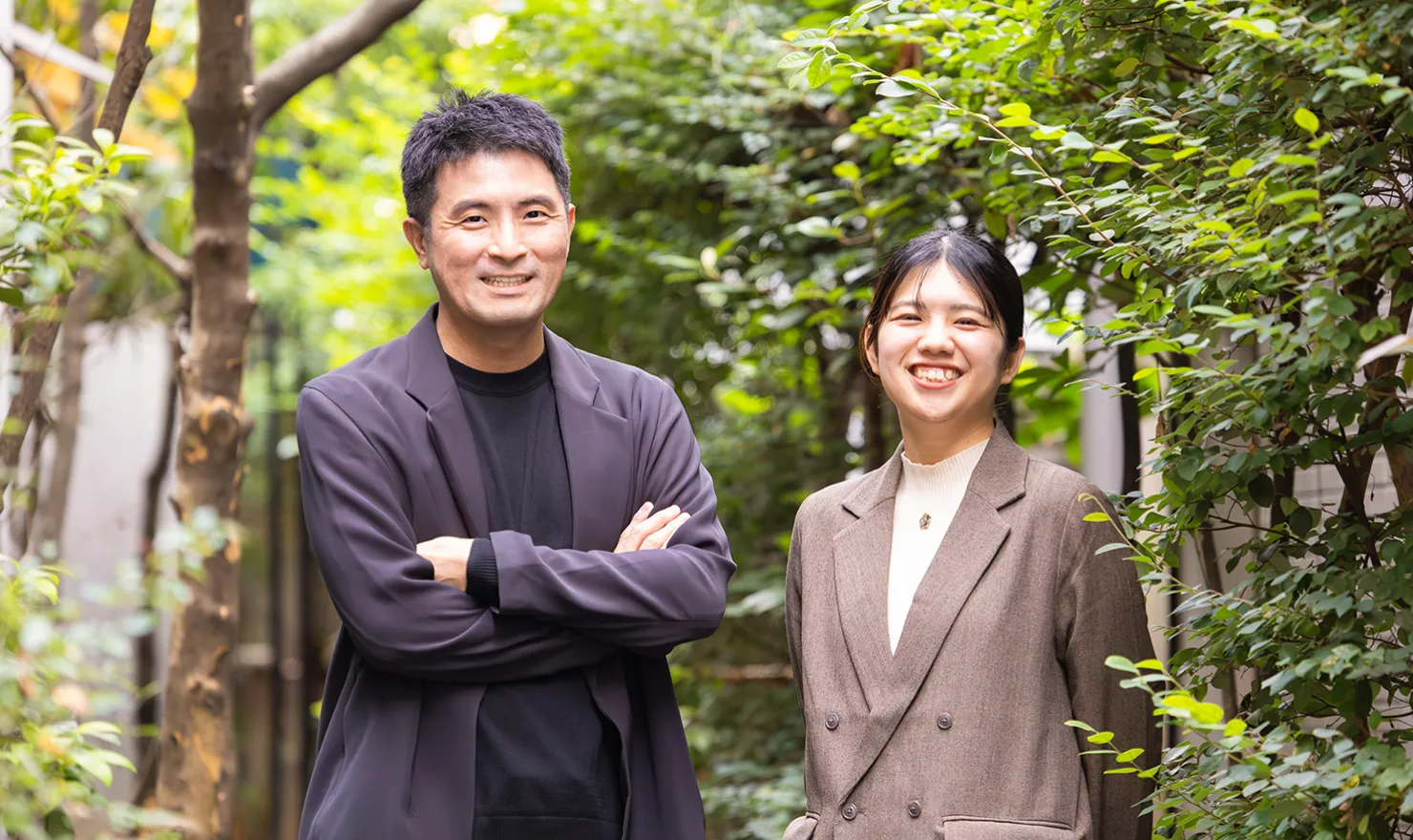 コンセントのコミュニケーションスペース「amu」を背景に、鈴木と大﨑が写るメインビジュアル。