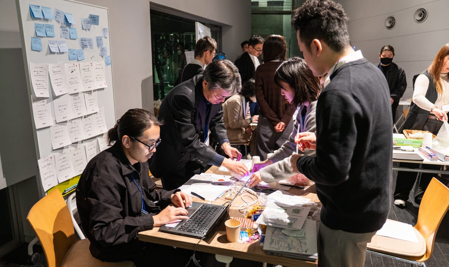 写真。実際にIoT試作機を触ってみながら、参加者同士で対話する様子。