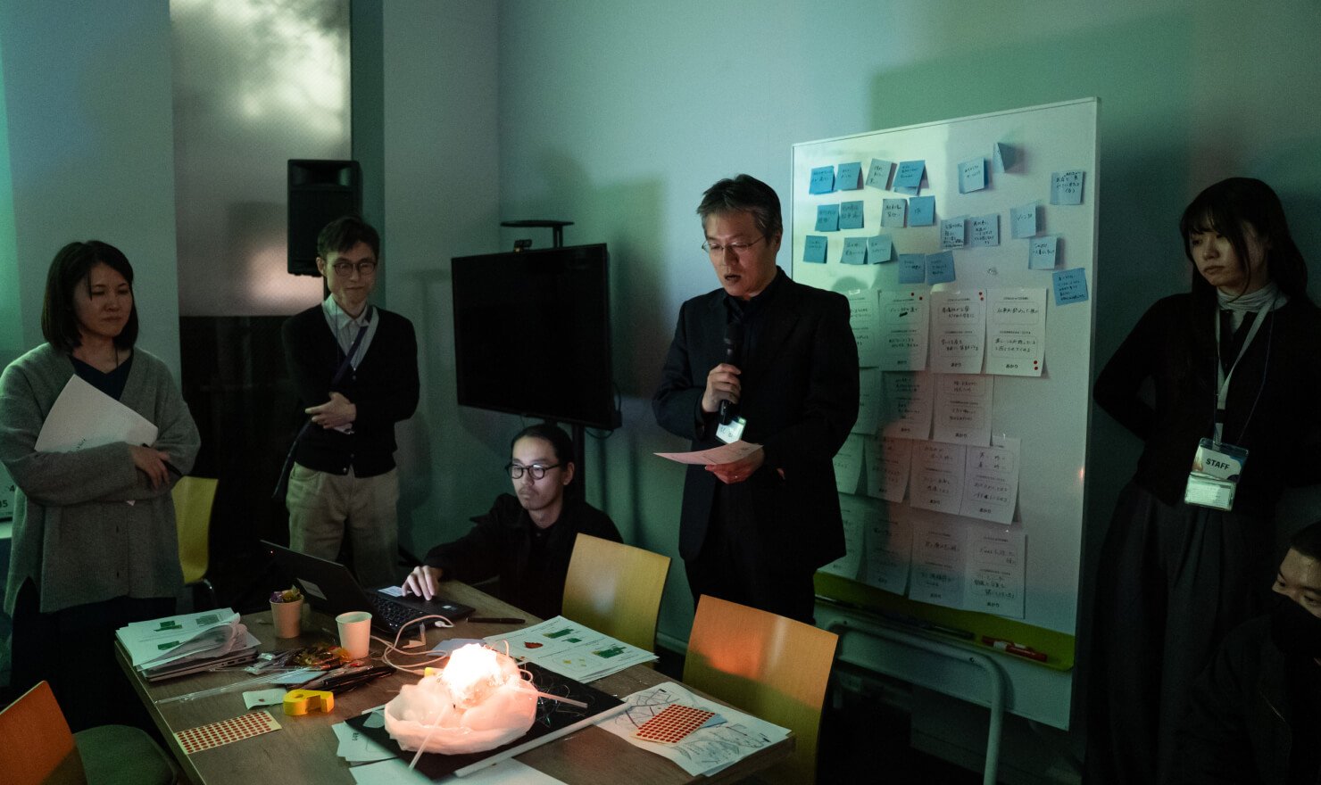 写真。参加者の1人がアイデア試作品について発表する様子。