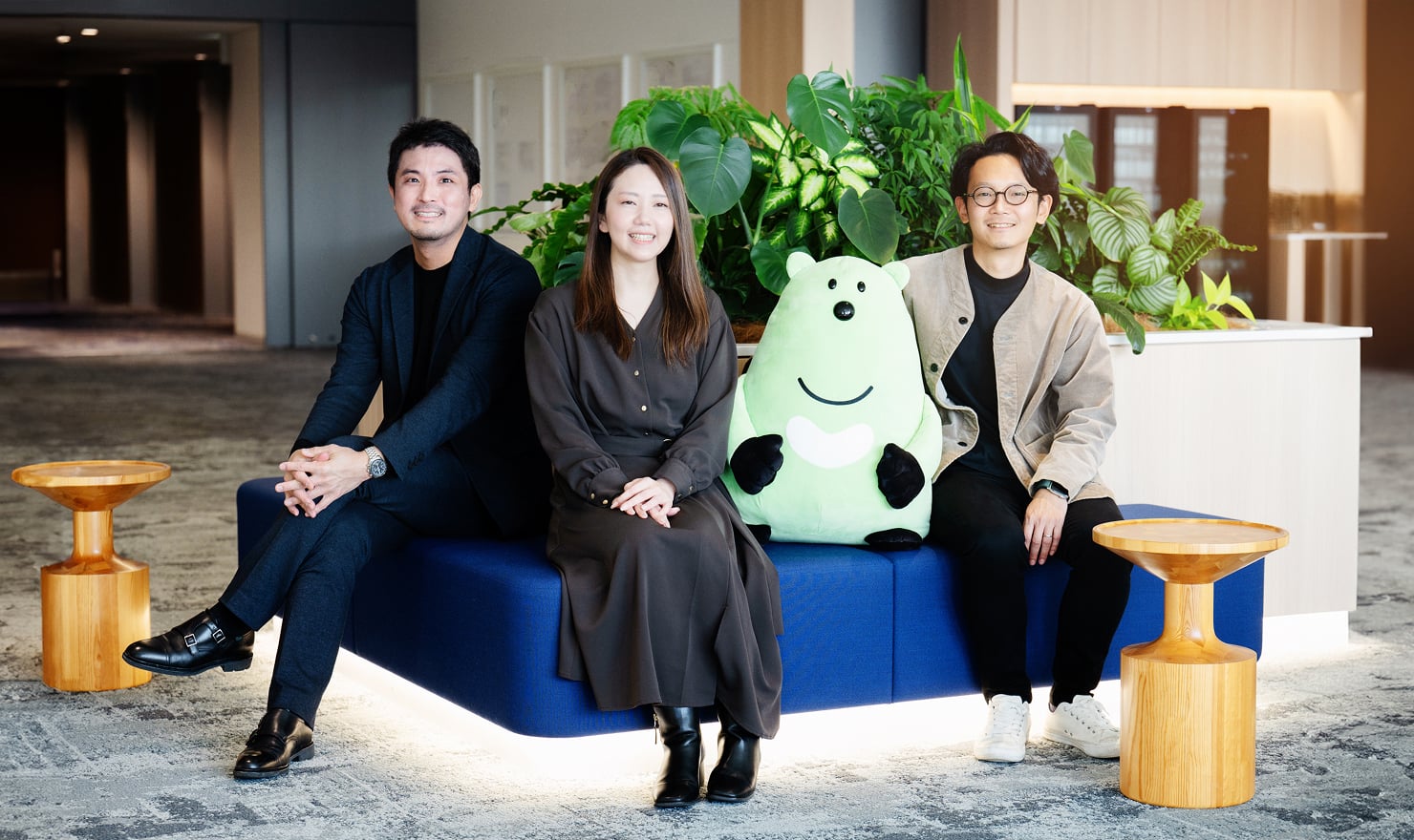 写真。左から大﨑、伊藤氏、金子氏が三井住友カード社のキャラクター人形とともにソファーに座って微笑んでいる。