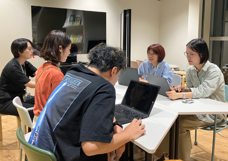 初訪RPGプログラム時の写真。参加者が机を囲んでロールプレイしている様子。