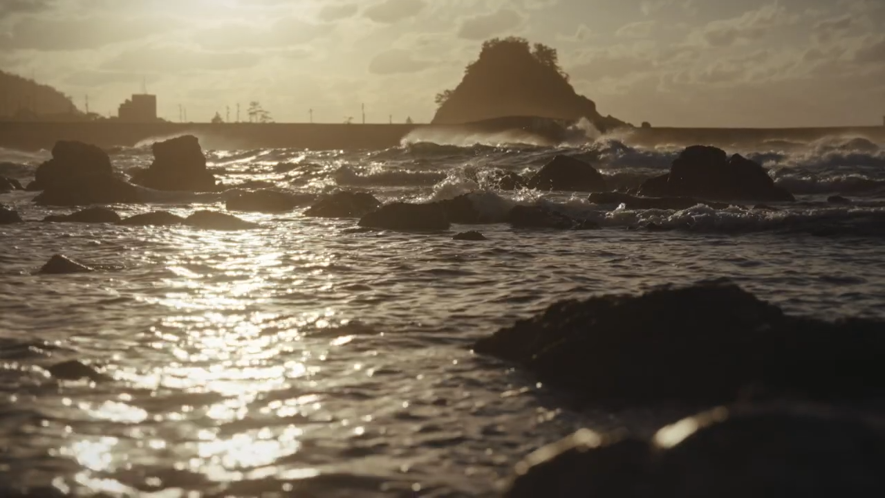 Season.2シーンカット。陽が差し込む岩場のある海の風景。