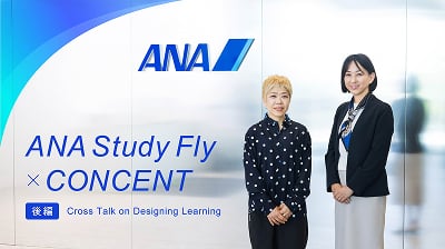 後編記事メインビジュアル。対談する二人が、ANAのロゴマークのある壁を背景に立っている様子。